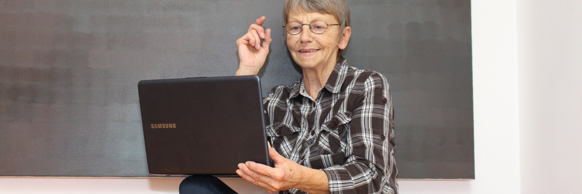 Seniorin schaut in Laptop. 