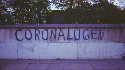 Auf einer Wand steht das Wort CORONALÜGEN. 