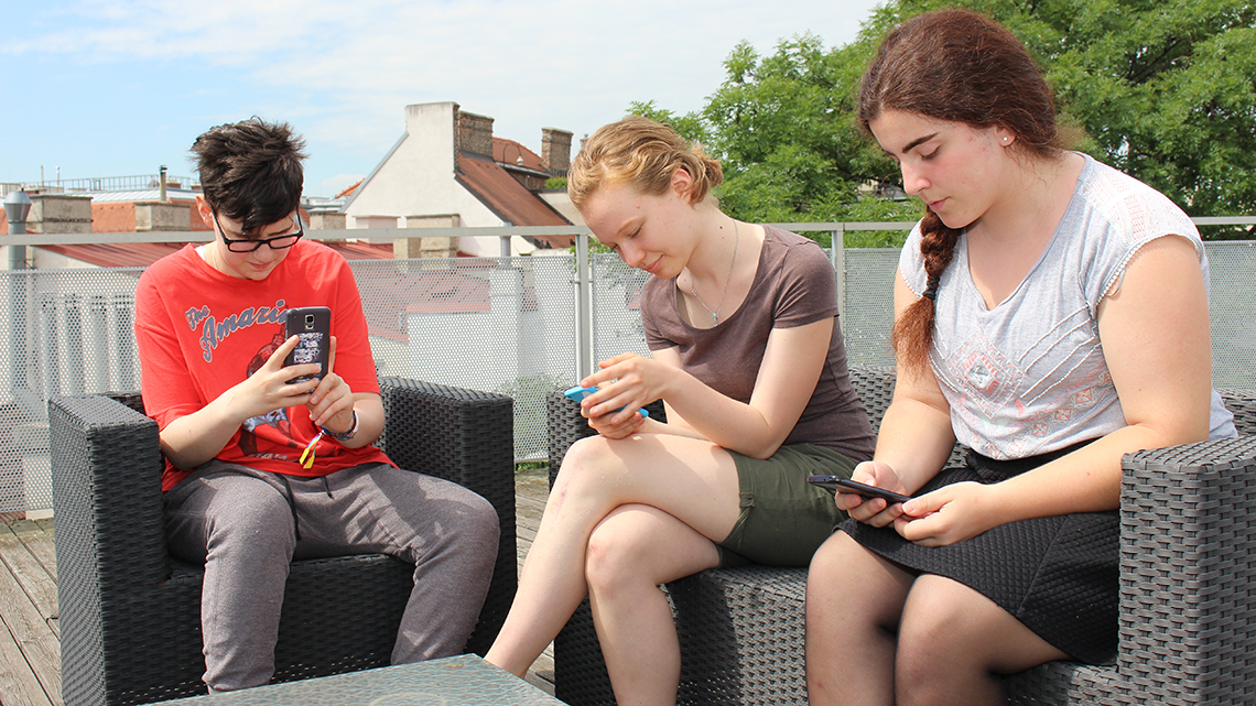 Jugendliche, die in ihre Handys schauen. 