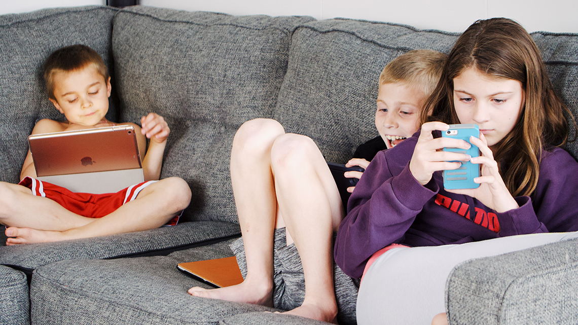 Kinder mit Handys und Tablet