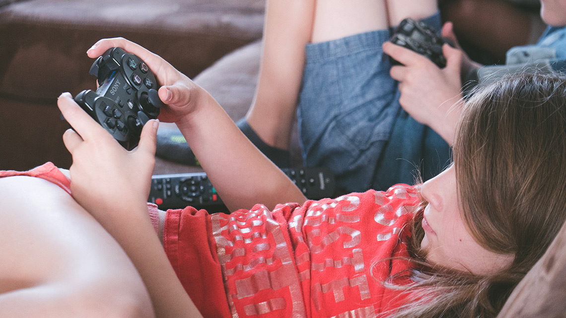 Mädchen und Bub spielen Computerspiele auf der Konsole